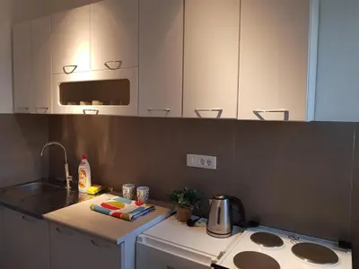 a kitchen with white cabinets and a sink and a stove at Spacious and comfortable apartment in Podgorica