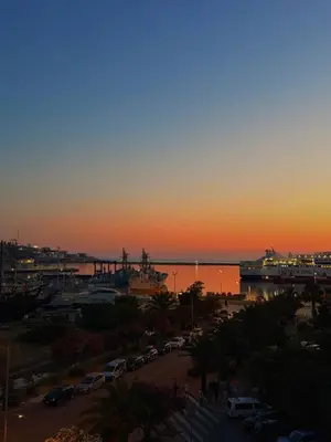 a sunset over a harbor with a cruise ship in the water at Porta Mare Apartment in Bar