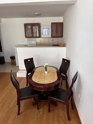 a table and chairs in a room with a kitchen at Summer Dreams Apartment in Budva