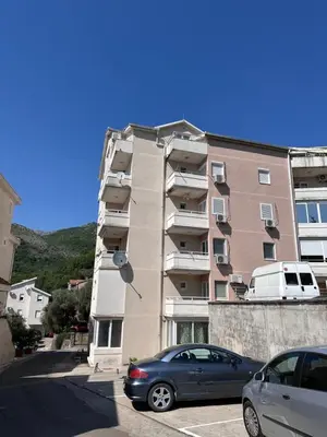 a apartment building with cars parked in front of it at Summer Dreams Apartment in Budva