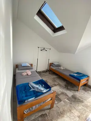 a room with two beds and a window at Bayview Apartments in Drobnići