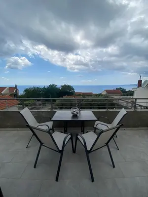 a table and chairs on a patio with a view at Bayview Apartments in Drobnići