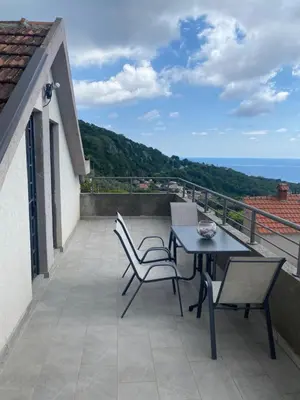 a patio with a table and chairs on a balcony at Bayview Apartments in Drobnići