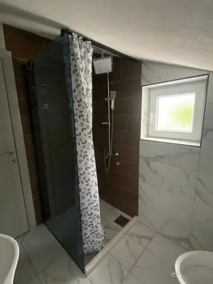 a bathroom with a shower with a shower curtain at Bayview Apartments in Drobnići