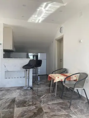 a kitchen with a table and chairs in a room at Bayview Apartments in Drobnići