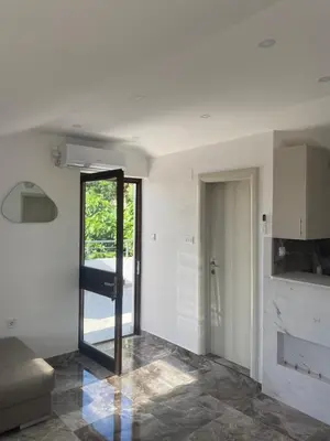 a living room with a glass door leading to a bathroom at Bayview Apartments in Drobnići