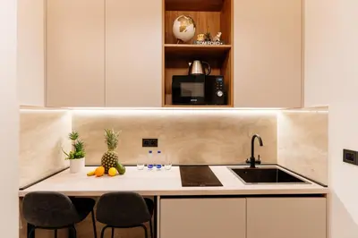a kitchen with a sink and a counter with chairs at Avenza Residences Kotor Old Town in Kotor