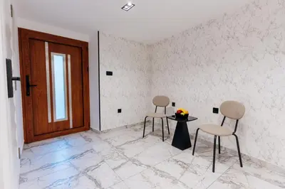 two chairs and a table in a room with a door at Avenza Residences Kotor Old Town in Kotor