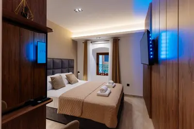 a hotel room with a bed and a flat screen tv at Avenza Residences Kotor Old Town in Kotor