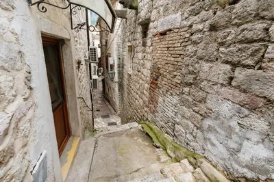 an alley in an old stone building with a door at Avenza Residences Kotor Old Town in Kotor