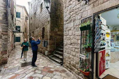 a man taking a picture of a woman in an alley at Avenza Residences Kotor Old Town in Kotor