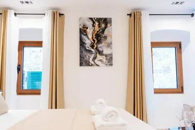 a bedroom with a bed and two windows at Avenza Residences Kotor Old Town in Kotor