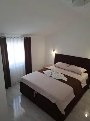 a bedroom with a large bed with a large window at Milovic Apartman in Kotor