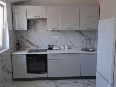 a white kitchen with white cabinets and a sink at Milovic Apartman in Kotor