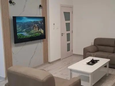 a living room with a couch and a tv on a wall at Milovic Apartman in Kotor