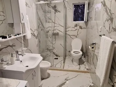 a bathroom with a shower and a toilet and a sink at Milovic Apartman in Kotor