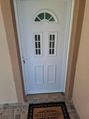 a white door in a hallway with a rug at Milovic Apartman in Kotor