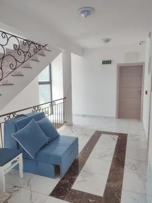 a living room with a blue couch and a staircase at Adam & Eve Family Apartment in Dobra Voda