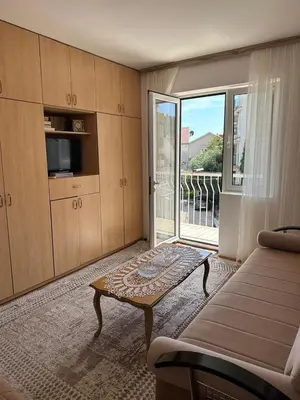 a living room with a coffee table and a balcony at Apartman Centar in Petrovac na Moru