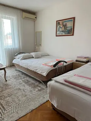 a bedroom with two beds and a window at Apartman Centar in Petrovac na Moru