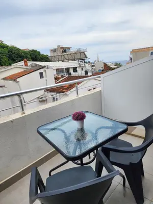 a glass table and a chair on a balcony at Beach Center in Ulcinj