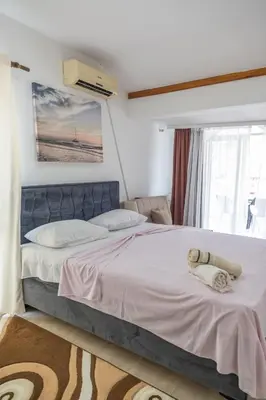 a bedroom with a large bed with white sheets at Beach Center in Ulcinj