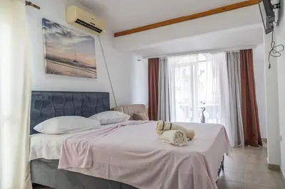 a bedroom with two beds and a large window at Beach Center in Ulcinj
