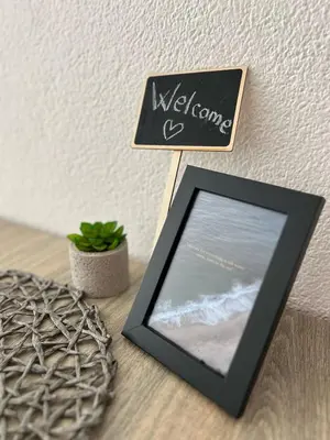 a picture frame sitting on a table with a welcome sign at Apartmani MalaPlaza in Ulcinj