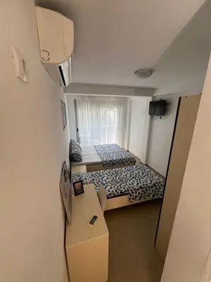 a small room with two beds and a table at Apartmani MalaPlaza in Ulcinj