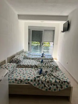 a bedroom with two beds and a window at Apartmani MalaPlaza in Ulcinj