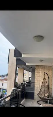 a building with a balcony with chairs and a chandelier at Apartmani MalaPlaza in Ulcinj
