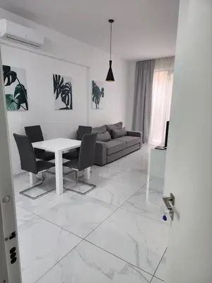 a white living room with a table and a couch at Apartment Del Mare in Boreti