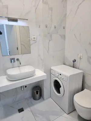 a white bathroom with a washing machine and a sink at Apartment Del Mare in Boreti