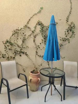 a table with a blue umbrella and two chairs at Apartment Del Mare in Boreti