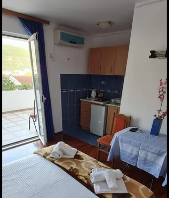 a room with a kitchen with a table and a kitchen at Nina Apartment 5 in Budva