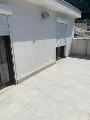 a white building with two windows and a patio at Darkobd in Budva