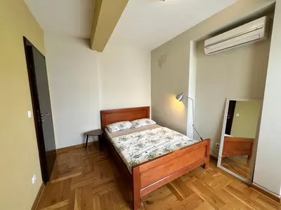 a bedroom with a bed and a lamp and a mirror at Apartment Sea Point in Becici