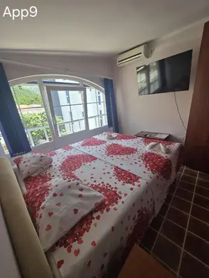 a bedroom with a bed covered in red flowers at Sveti Georgie Apartments in Becici