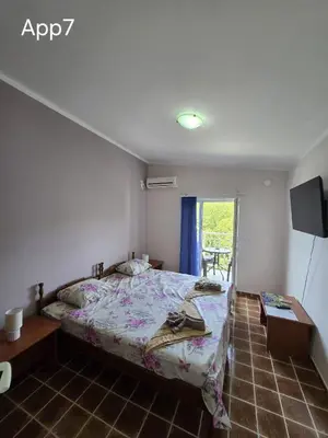 a bedroom with a bed and a tv and a window at Sveti Georgie Apartments in Becici