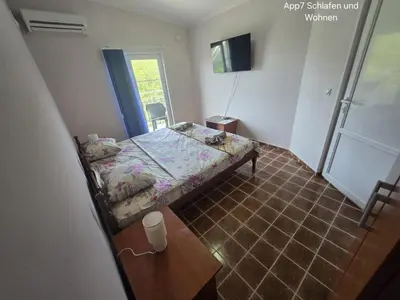 a small bedroom with a bed and a table at Sveti Georgie Apartments in Becici