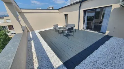 a deck with chairs and a table on a building at Loft Apartment in Podgorica