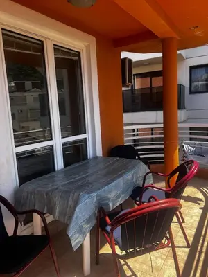 a table and chairs on a balcony with a table and windows at Better place in Becici