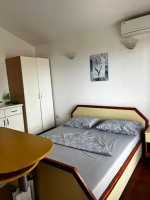 a small bedroom with a bed and a table at Better place in Becici
