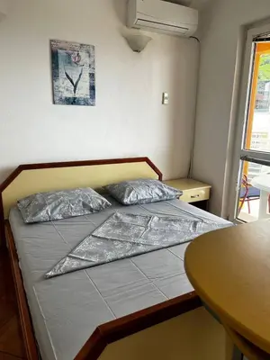 a bed in a small room with a table at Better place in Becici