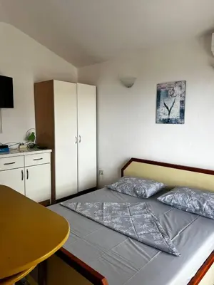 a small bedroom with a bed and a table at Better place in Becici
