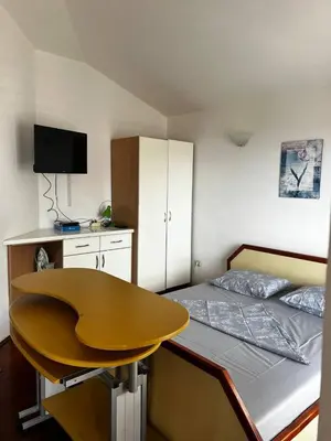a bedroom with a bed with a desk and a table at Better place in Becici