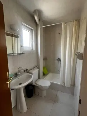 a white bathroom with a toilet and a sink at Better place in Becici