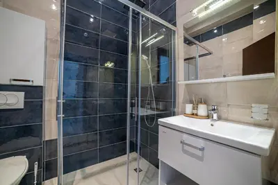 a bathroom with a shower and a toilet and a sink at The Royal Summer & Spa in Becici