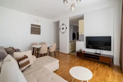 a living room with a couch and a tv and a table at The Royal Summer & Spa in Becici