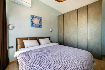 a bedroom with a large bed with a wooden headboard at The Royal Summer & Spa in Becici